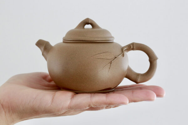 Aged Zisha Teapot on top of hand - Duanni Clay with Artisan Design on top of hand