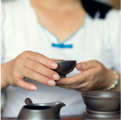 A woman is holding a cup of tea.