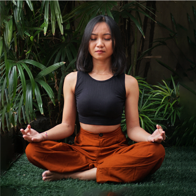 A young asian woman meditating in a lotus position.