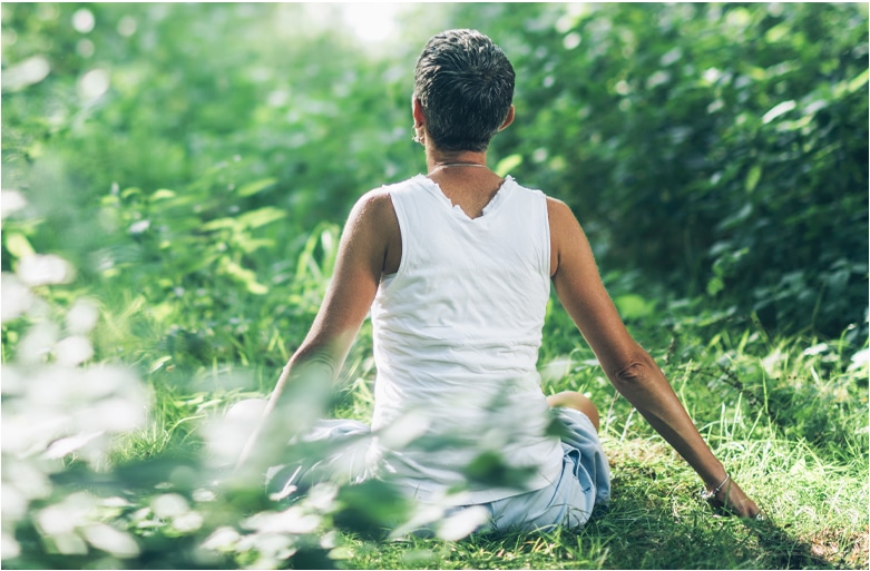 A woman meditating in the forest.