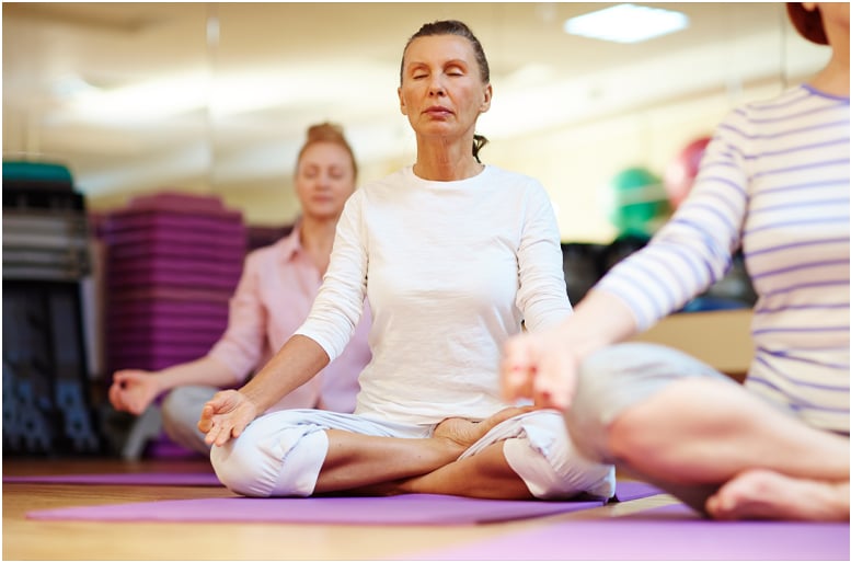 A group of women meditating in a yoga studio.